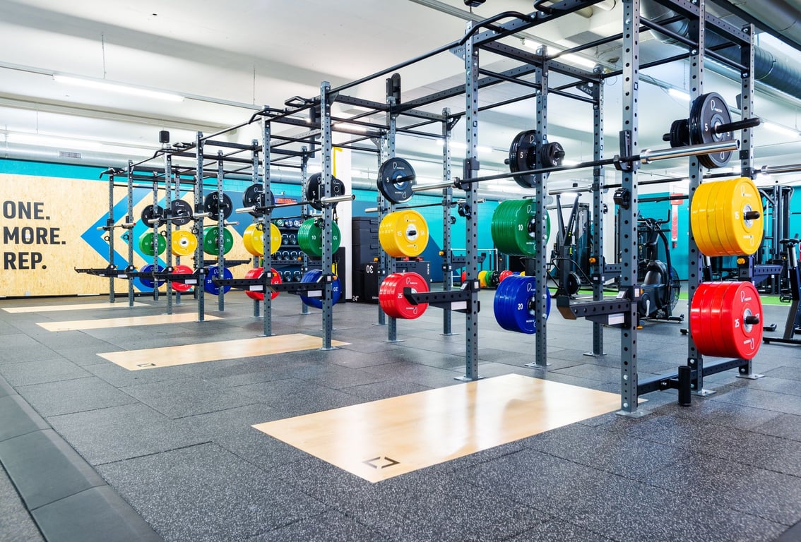 PureGym Dübendorf: Kraftraum mit Hockstützen und bunten Hantelscheiben auf den Gestellen.