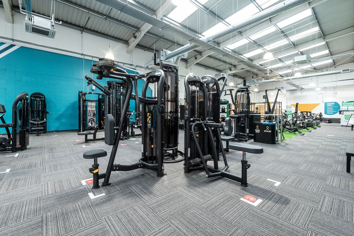 PureGym Stockport North: Resistance machines, benches, free weights, and rubberized flooring in a gym setting.