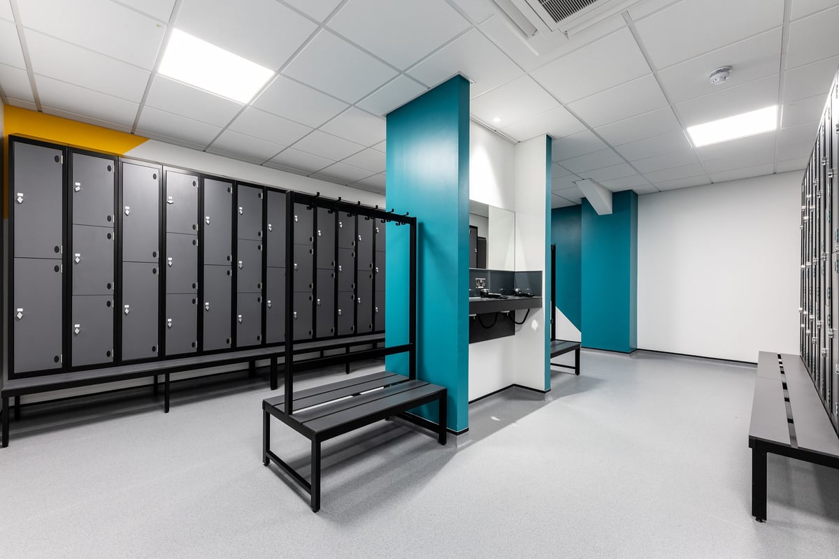 PureGym Sevenoaks: Rows of lockers, benches, and a changing area with teal accents.