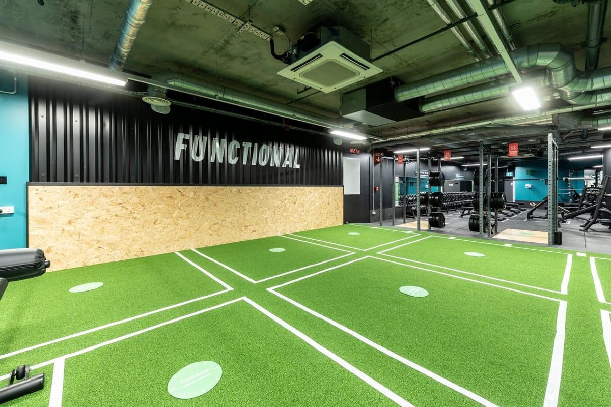 PureGym London Camberwell New Road: Green turf area with markings, weights, and equipment for functional training.