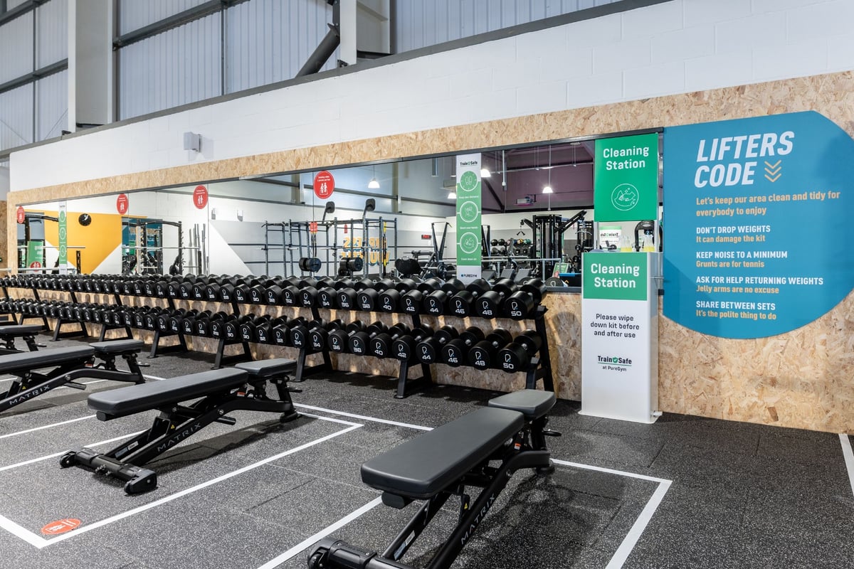 PureGym Gloucester Quedgeley: Workout benches and racks of free weight in a brightly lit gym