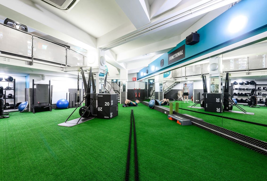 PureGym London St Pauls: Strength training area with turf flooring, weight racks, resistance machines, and wall mirrors.