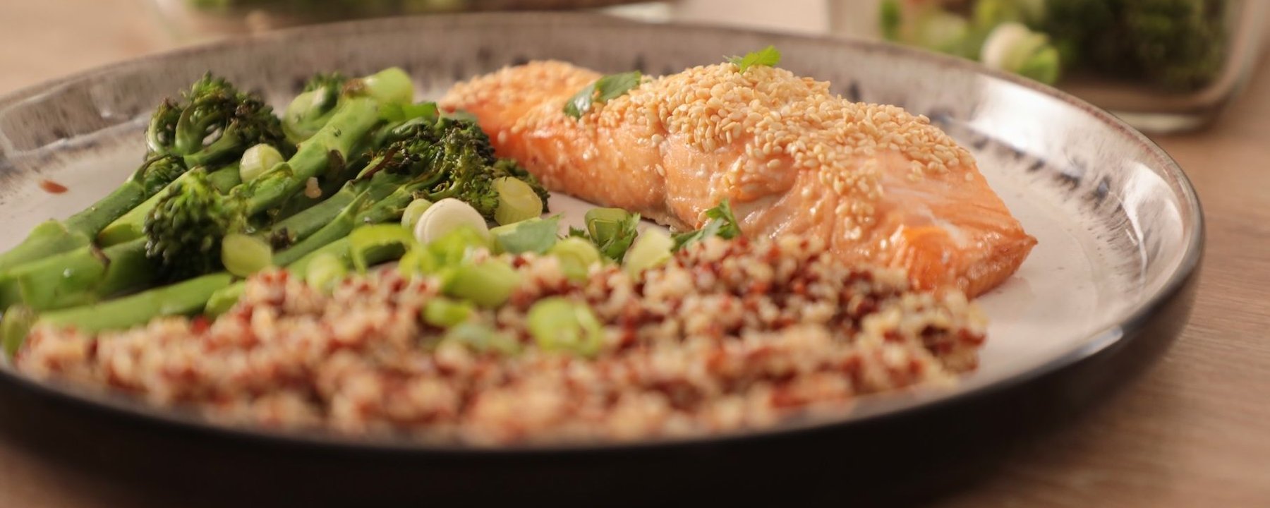 Sesame-crusted salmon fillet with quinoa and broccoli on a silver plate
