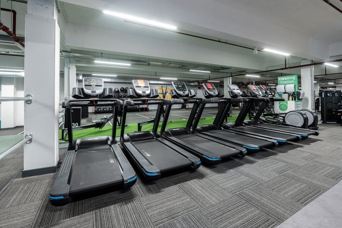 PureGym Gravesend: Rows of treadmills in a well-lit gym space with rubberised flooring.