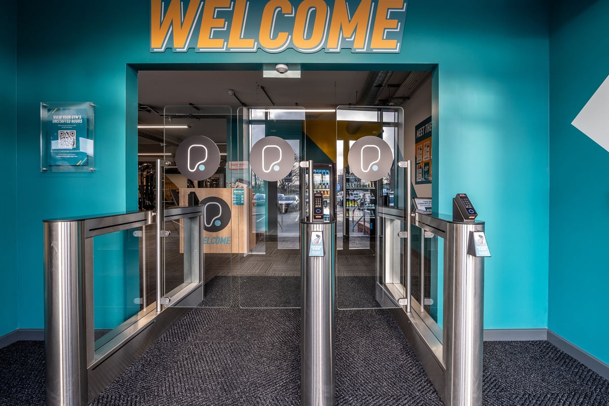 PureGym London Swanley: Welcome entrance with turnstiles, glass doors, and teal interior decor.