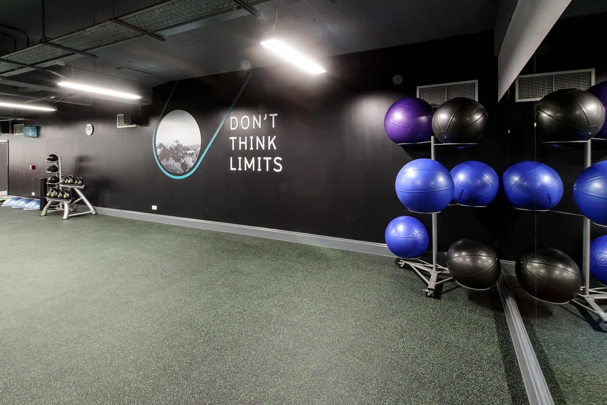 PureGym London Wembley: Exercise balls, rubberized flooring, motivational wall graphic stating "Don't think limits".