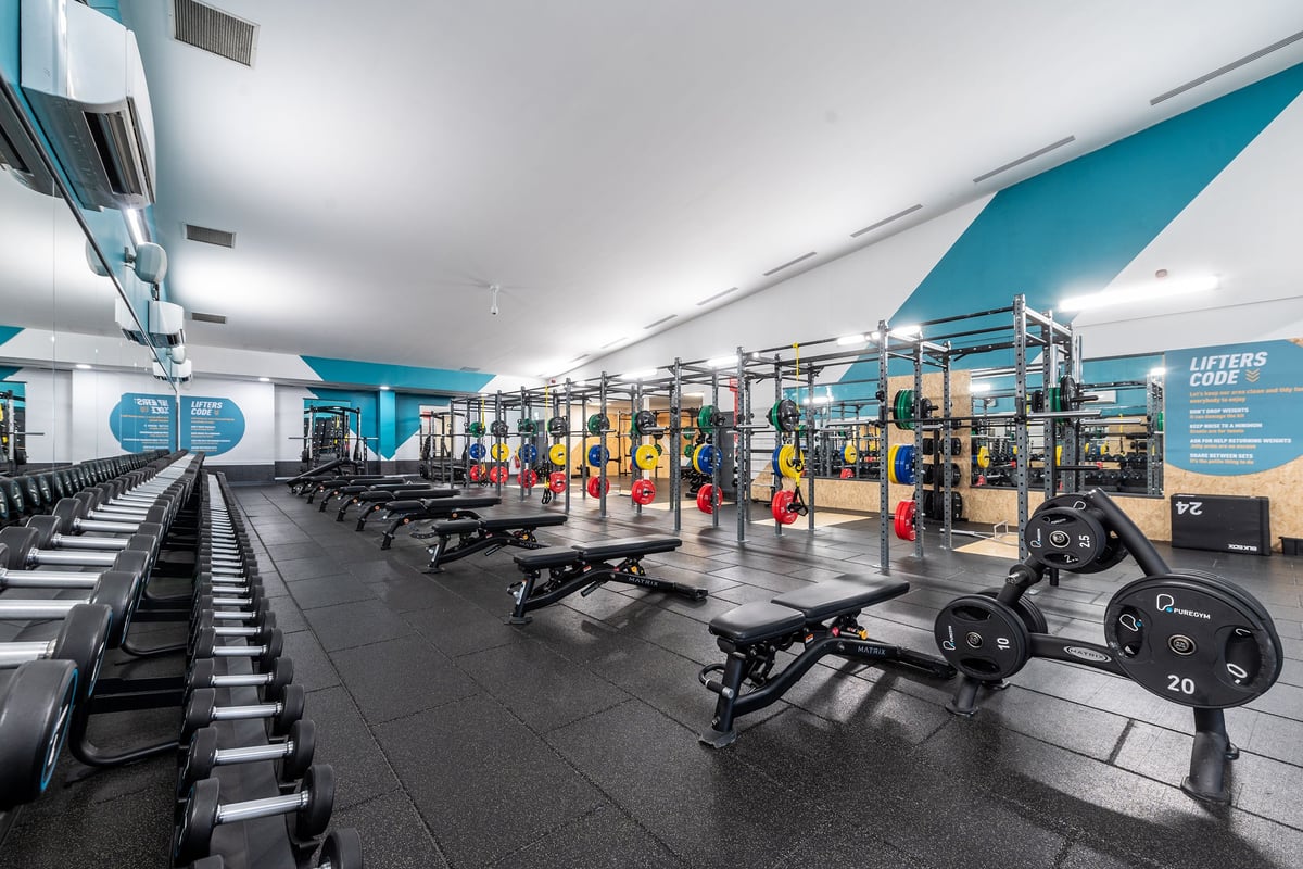 PureGym Loughborough: Rows of weight benches, dumbbell racks, resistance machines, and rubberized flooring in a gym studio.