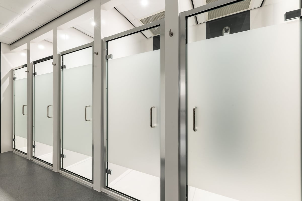 PureGym Sheffield Meadowhall Retail Park: Rows of frosted glass partitioned cubicles or changing rooms.