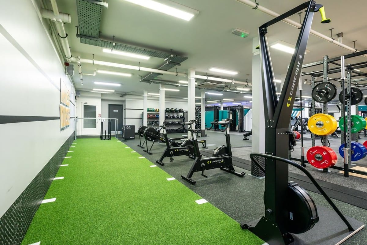 PureGym Wrexham: Weight machines, resistance bands, turf area, weight plates, benches, and rubberized flooring.
