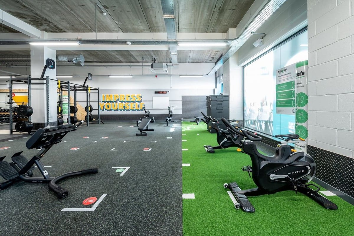 PureGym Chelmsford Meadows: Rowing machines, spin bikes, free weights, rubberized flooring, green turf area.