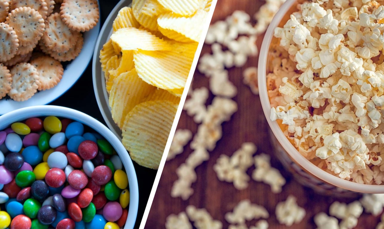 Bowls of popcorn, potato chips, colourful candy-coated chocolates, and crackers