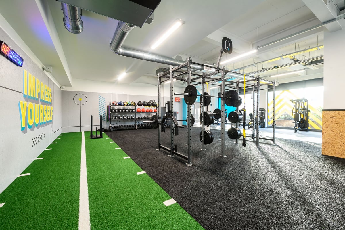 PureGym Telford: Strength rig, weight racks, medicine balls, turf area, rubberized flooring in a gym space.
