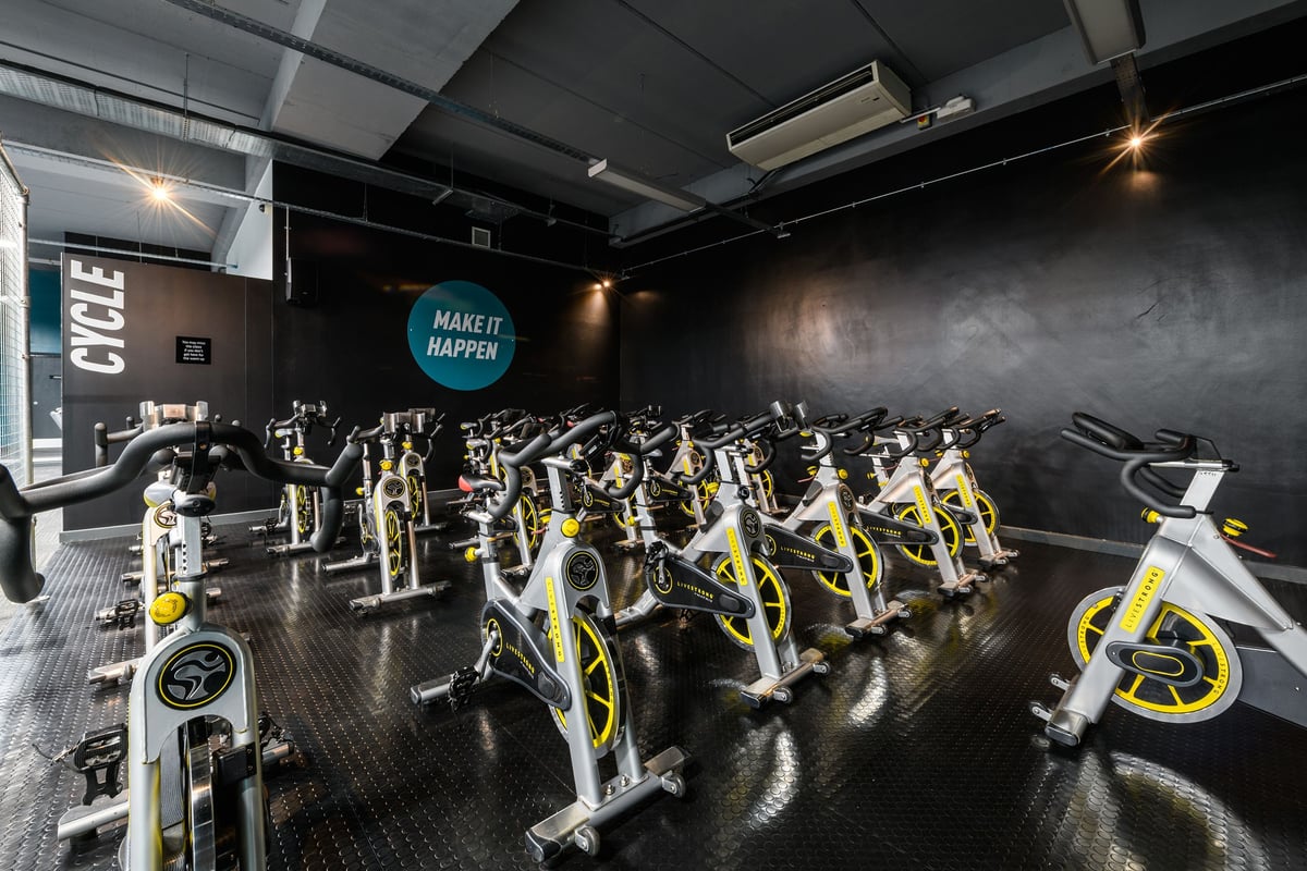 PureGym Bournemouth The Triangle: Rows of stationary bikes, sleek design, dark interior with motivational signage.