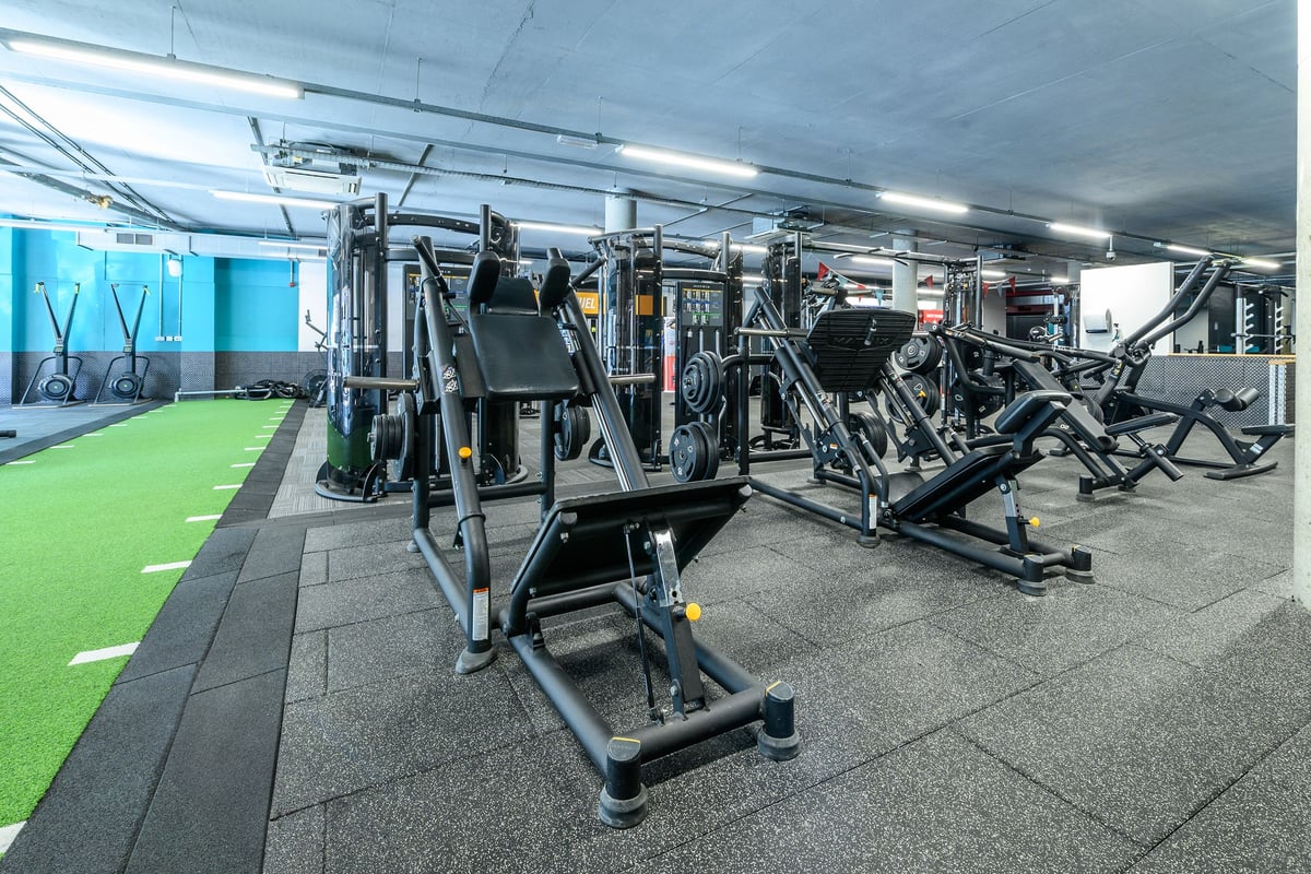 PureGym London Greenwich: Resistance machines, cable crossovers, squat racks, benches, and artificial turf flooring.