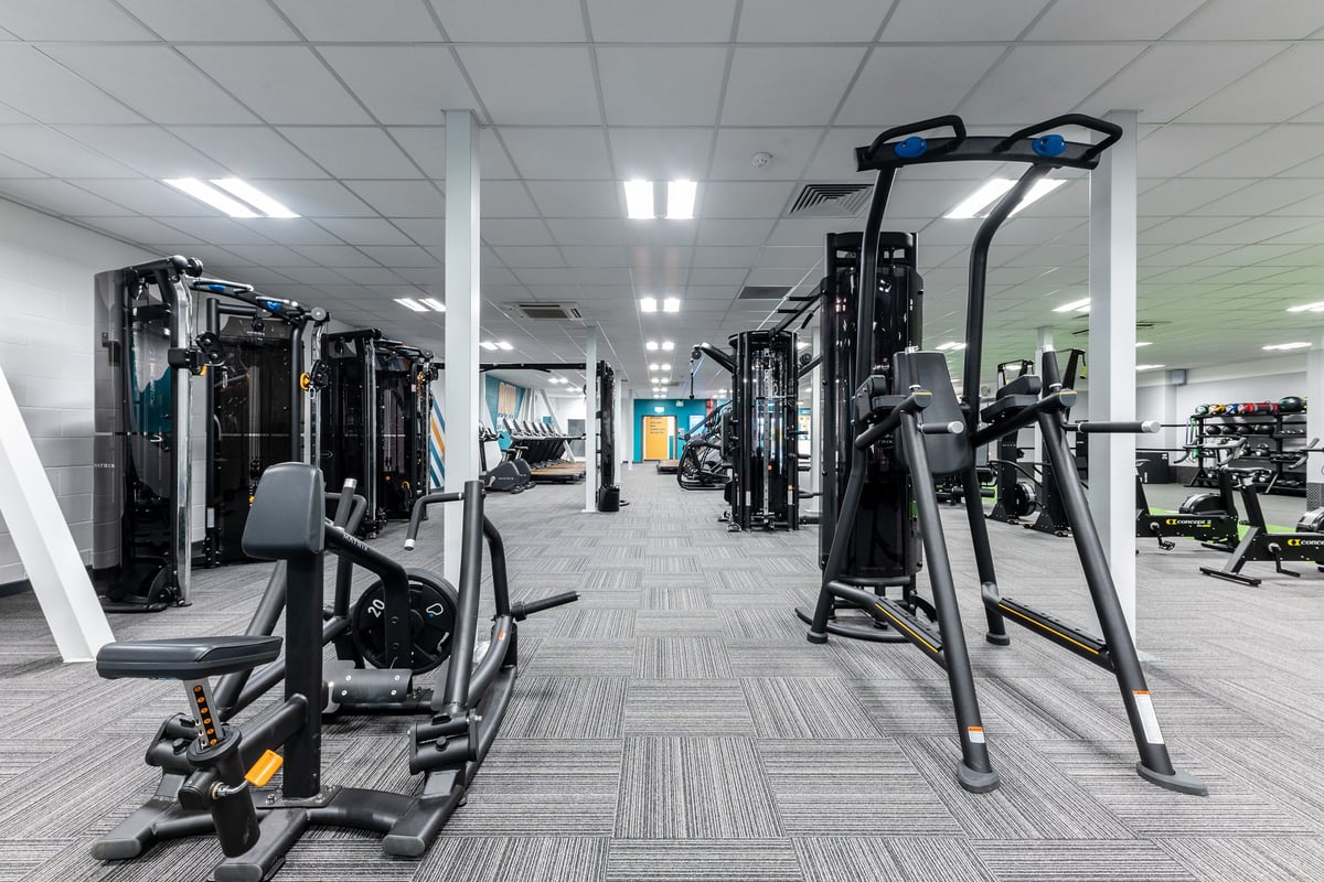 PureGym Gloucester Retail Park: Weight machines, cable crossover stations, and resistant training equipment in a gym setting.