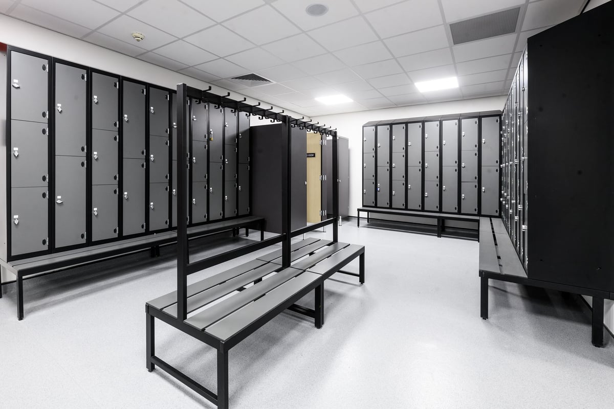 PureGym Aylesbury: Rows of lockers, benches in a changing room setting.