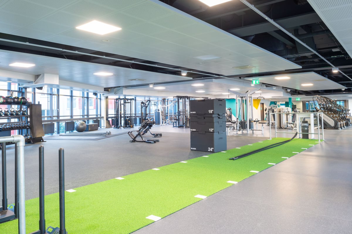 Grand espace fonctionnel de la gym Lochergut avec piste turf et boîtes plio