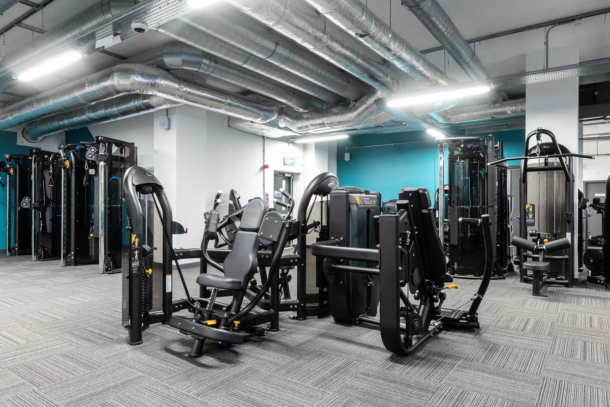 PureGym London Crouch End: Resistance machines, weight stacks, benches, and rubberized flooring in a gym setting.