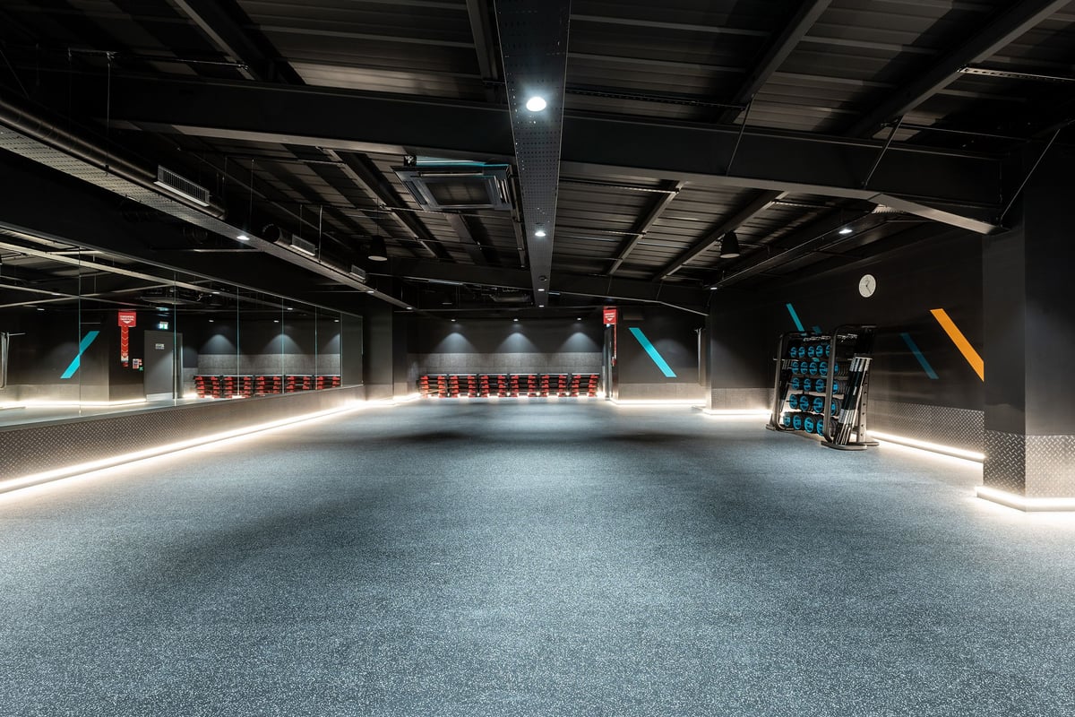 PureGym Durham Arnison: Interior space with mirrored walls, rubberized flooring, and exercise equipment.