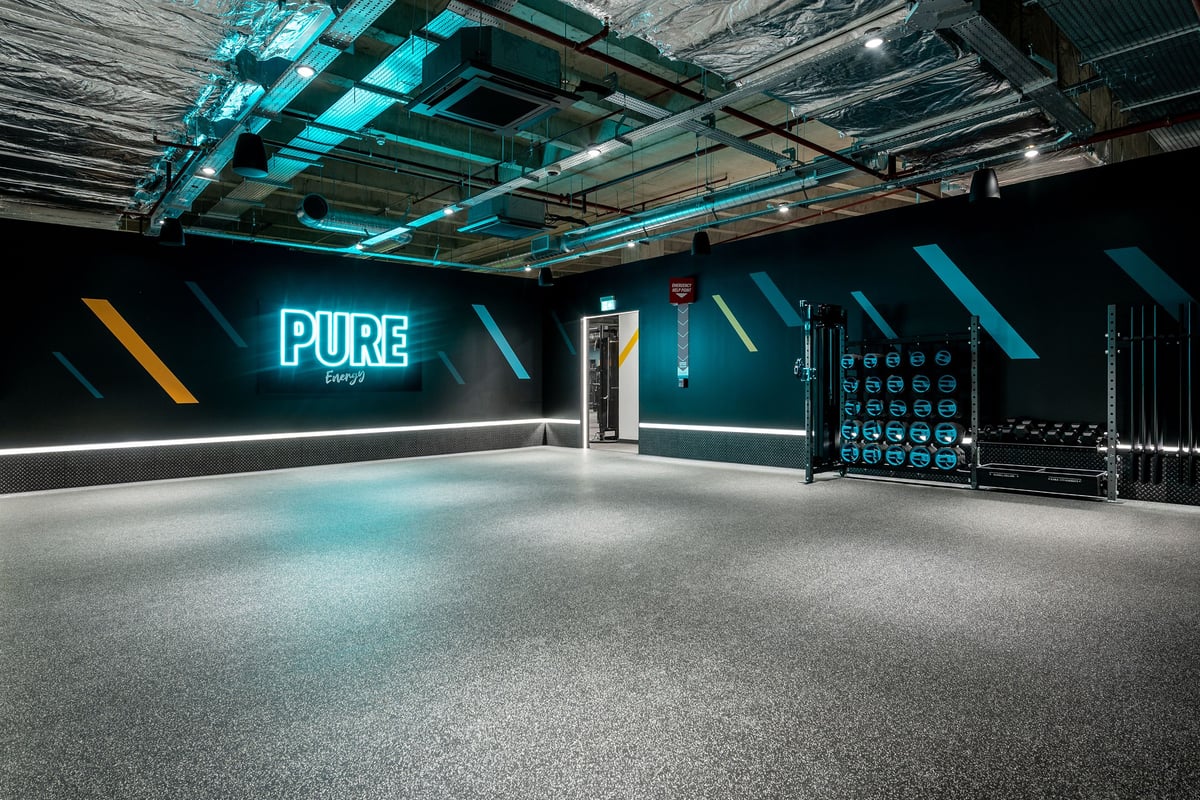 PureGym Uxbridge: Pure-branded gym studio interior with teal lighting, weight racks, resistance machines.