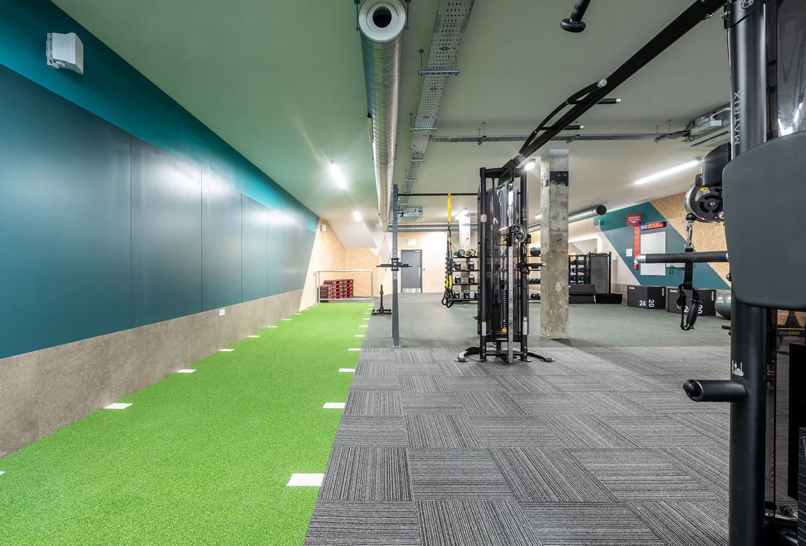 PureGym London Welling: Turf area, weight racks, benches, and mirrored walls in a modern gym studio.