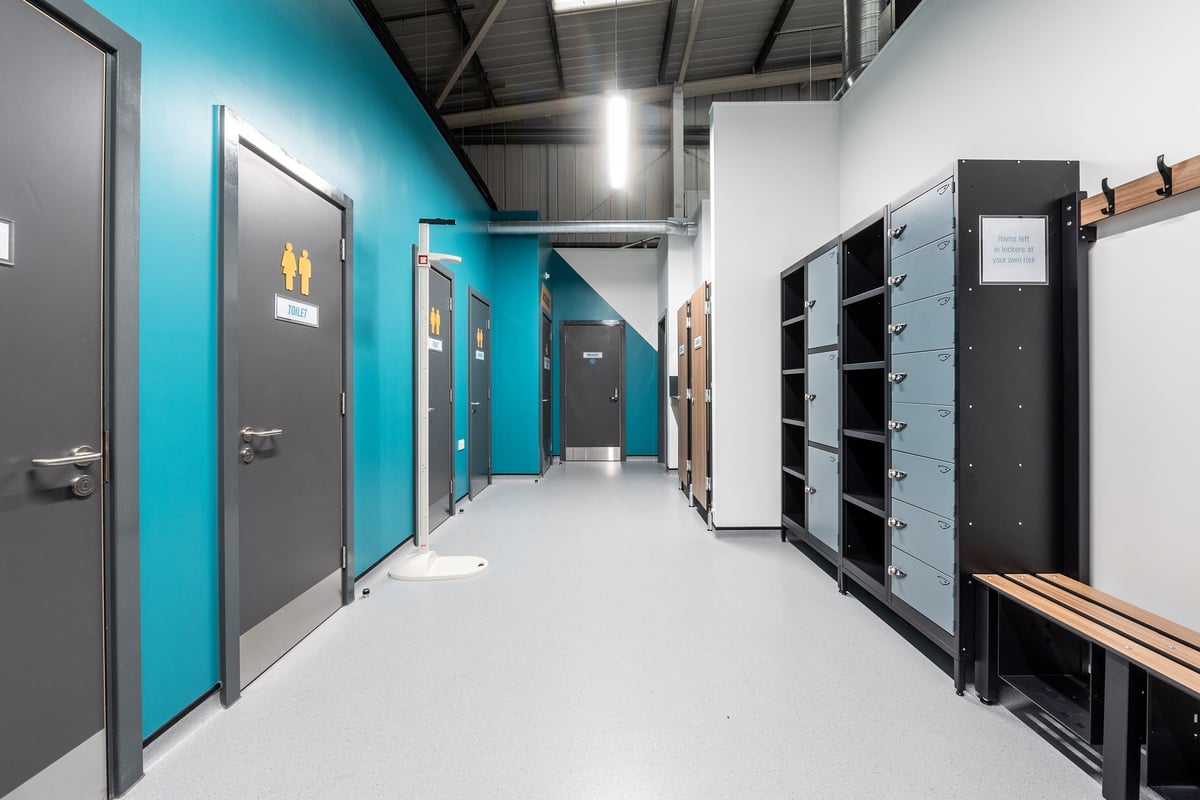 PureGym Newhaven: Rows of lockers, metal doors in teal and grey hues, long corridor-like space.