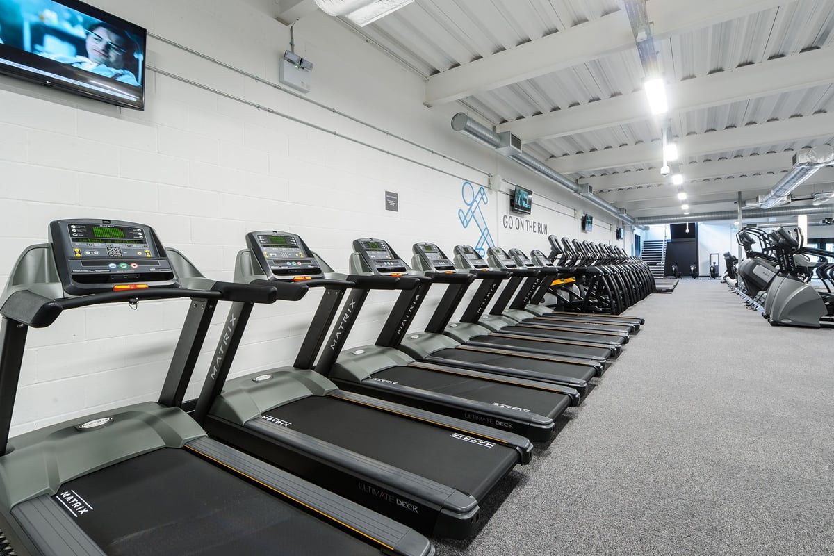 PureGym Leeds Regent Street: Rows of treadmills, cross-trainers, and stationary bikes in a brightly lit gym space.