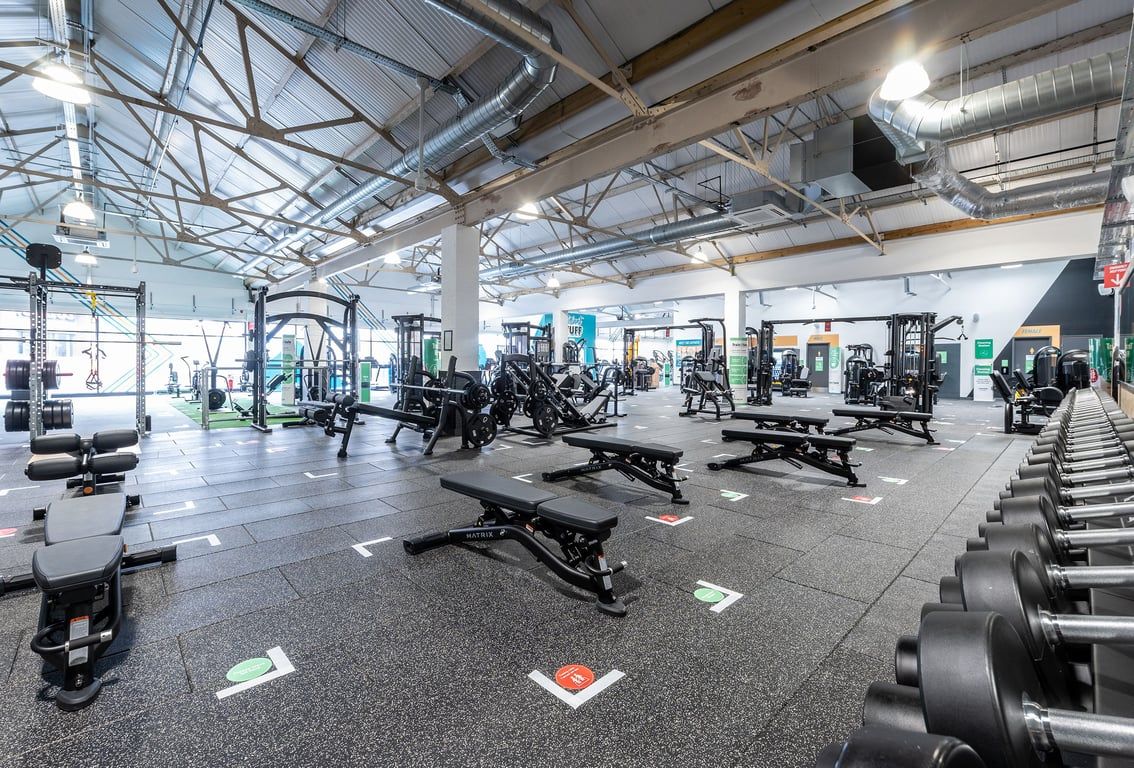 PureGym Puregym Crayford: Weight machines, benches, dumbbells, barbells, and rubberized flooring in a spacious gym interior.