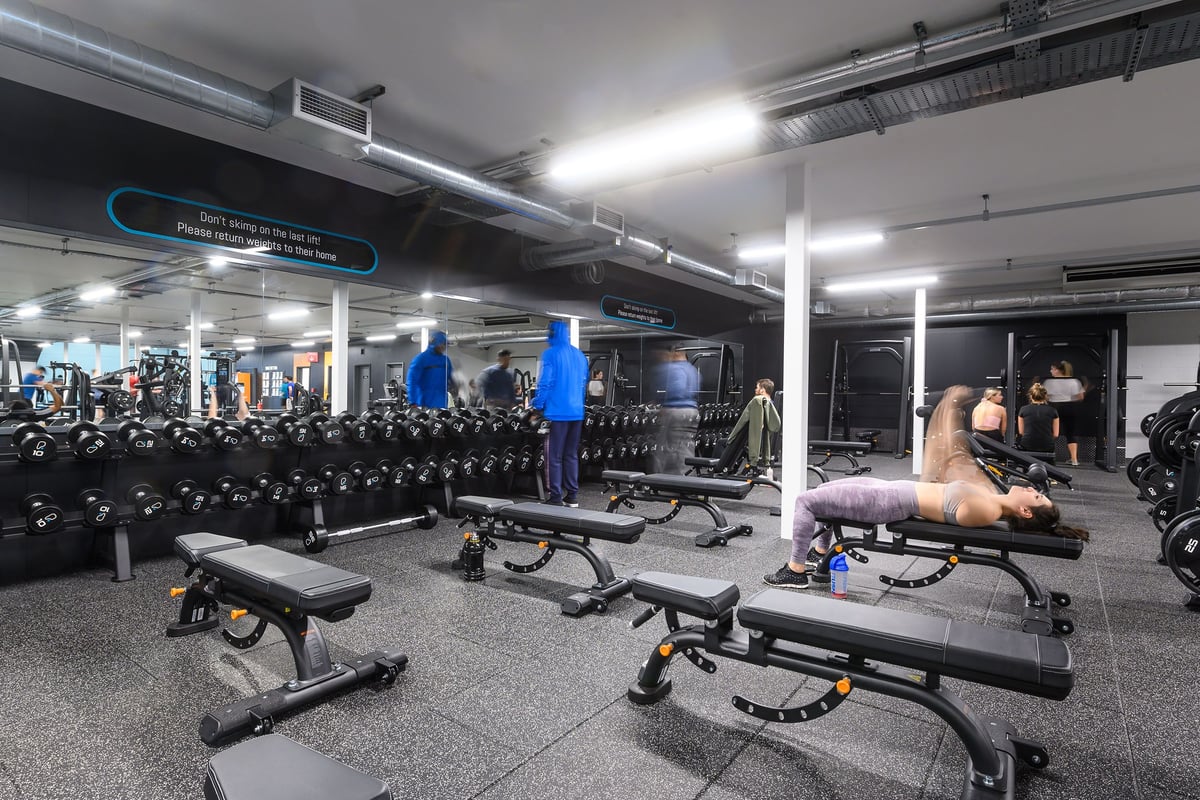 PureGym Bristol Abbey Wood Retail Park: Rows of weight benches, dumbbells, and strength training equipment in a well-lit gym.