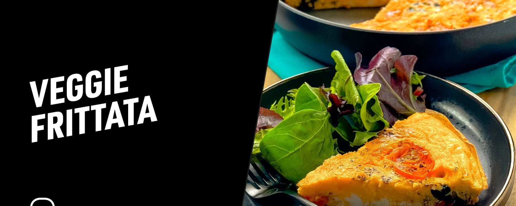 Slice of veggie frittata on a plate with mixed salad leaves and a fork nearby