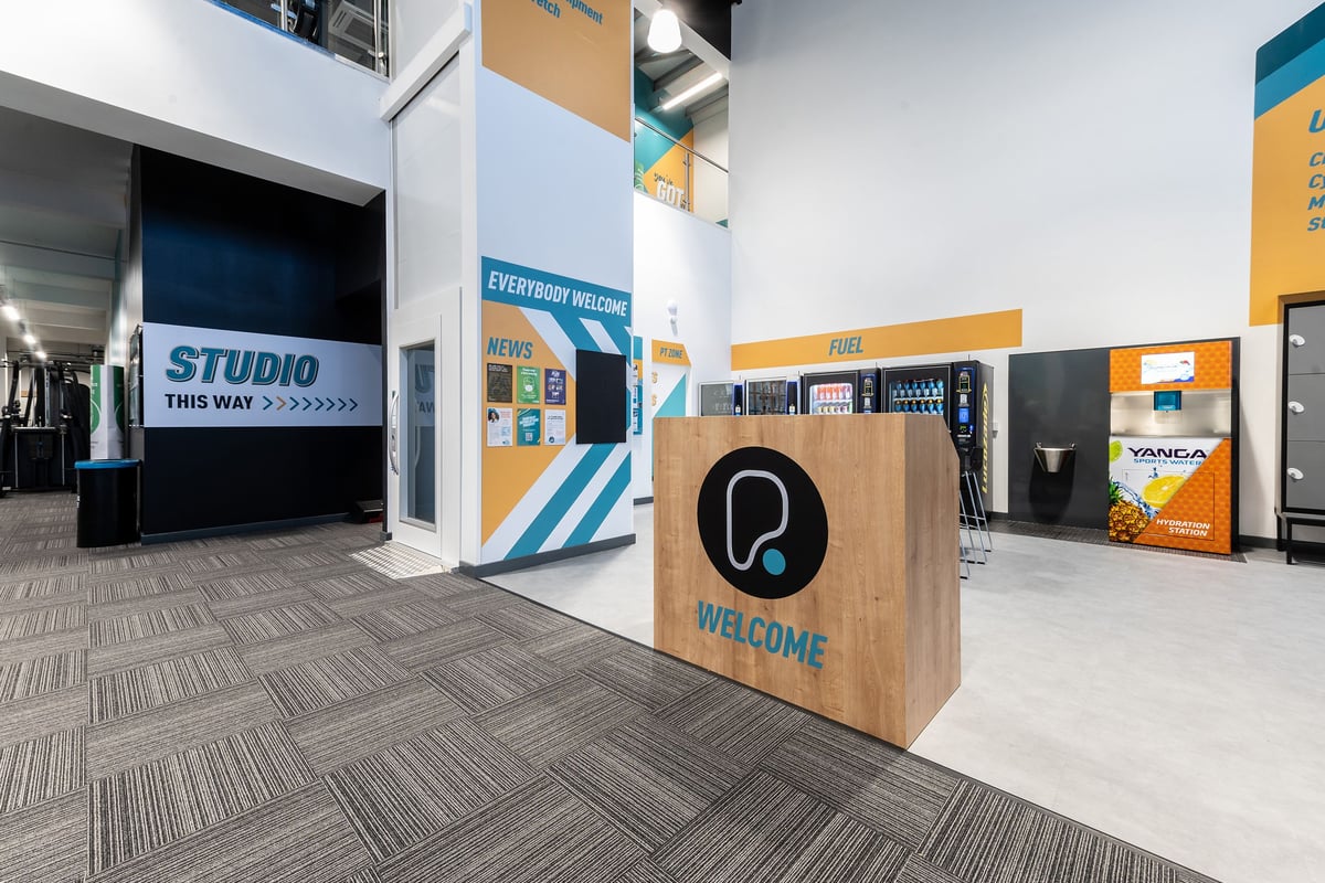 PureGym Edinburgh Craigleith Retail Park: Gym entry lobby with branding, information screens and welcome sign.