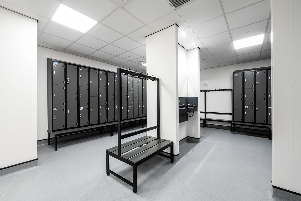 PureGym Torquay Bridge Retail Park: Lockers, benches, and minimal decor in a utilitarian changing room setting.
