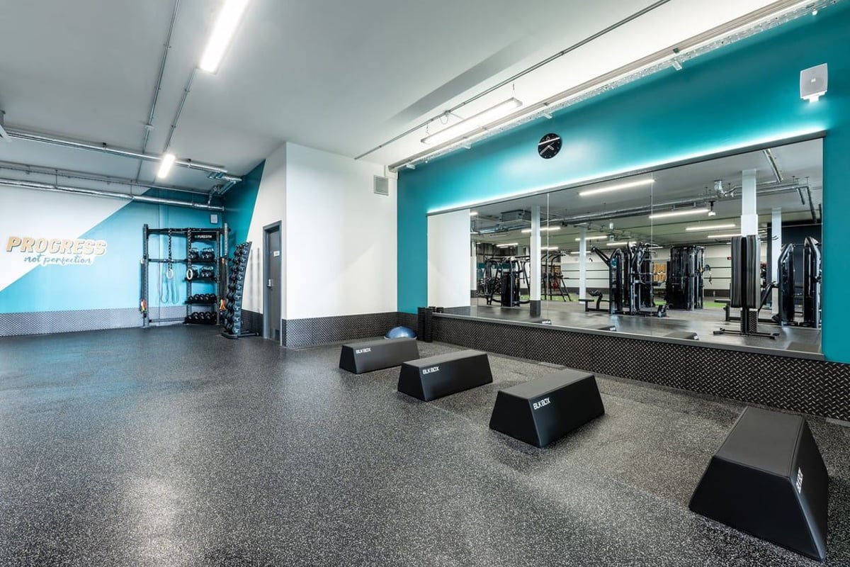 PureGym Tamworth: Functional training zone with step platforms, free weights, and turquoise-colored walls.