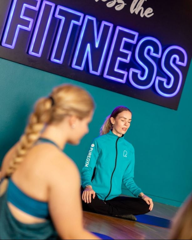 PureGym member and instructor doing Yoga