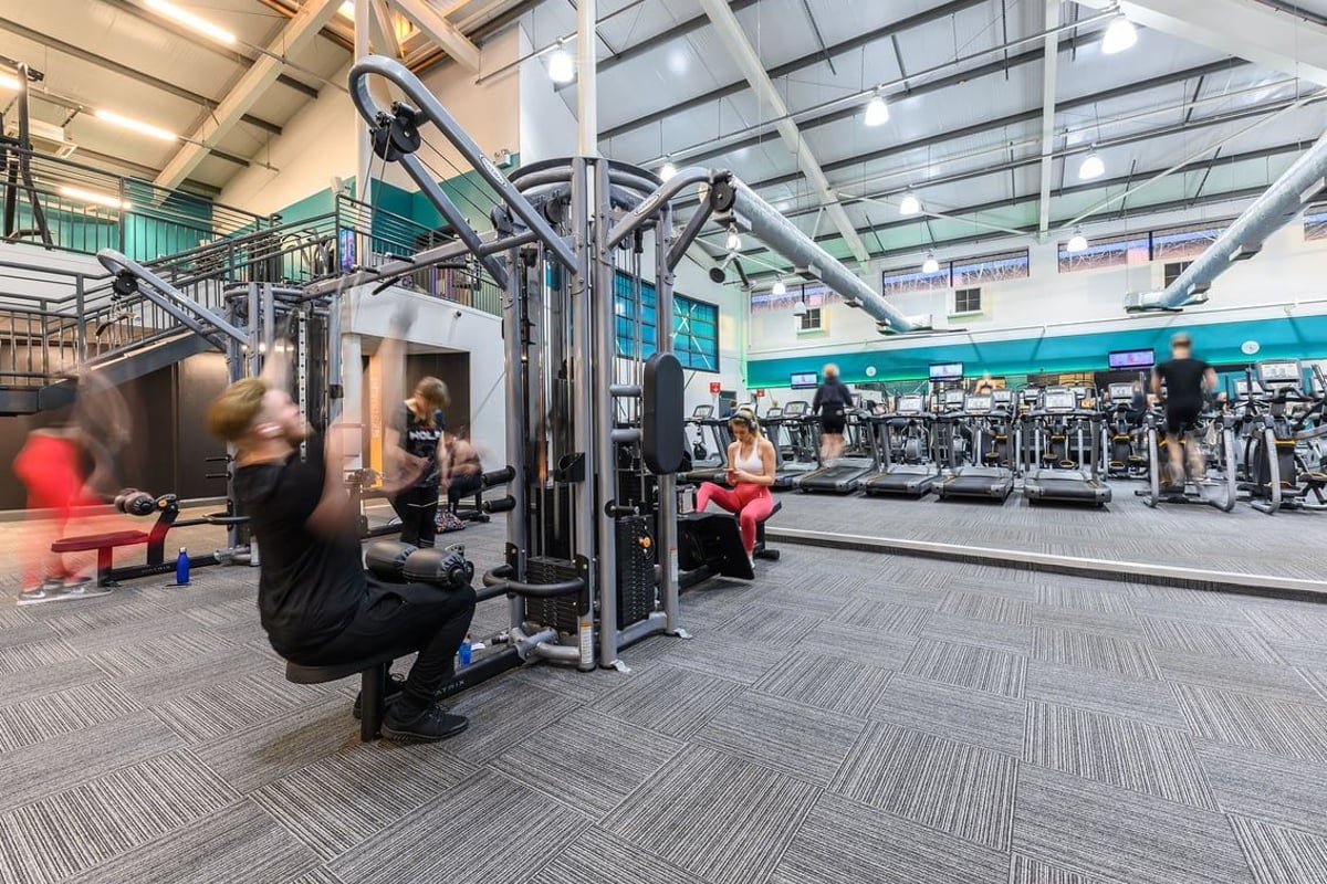 PureGym Mansfield: Weight machines, resistance cable stations, benches, and rubberized flooring in a gym setup.