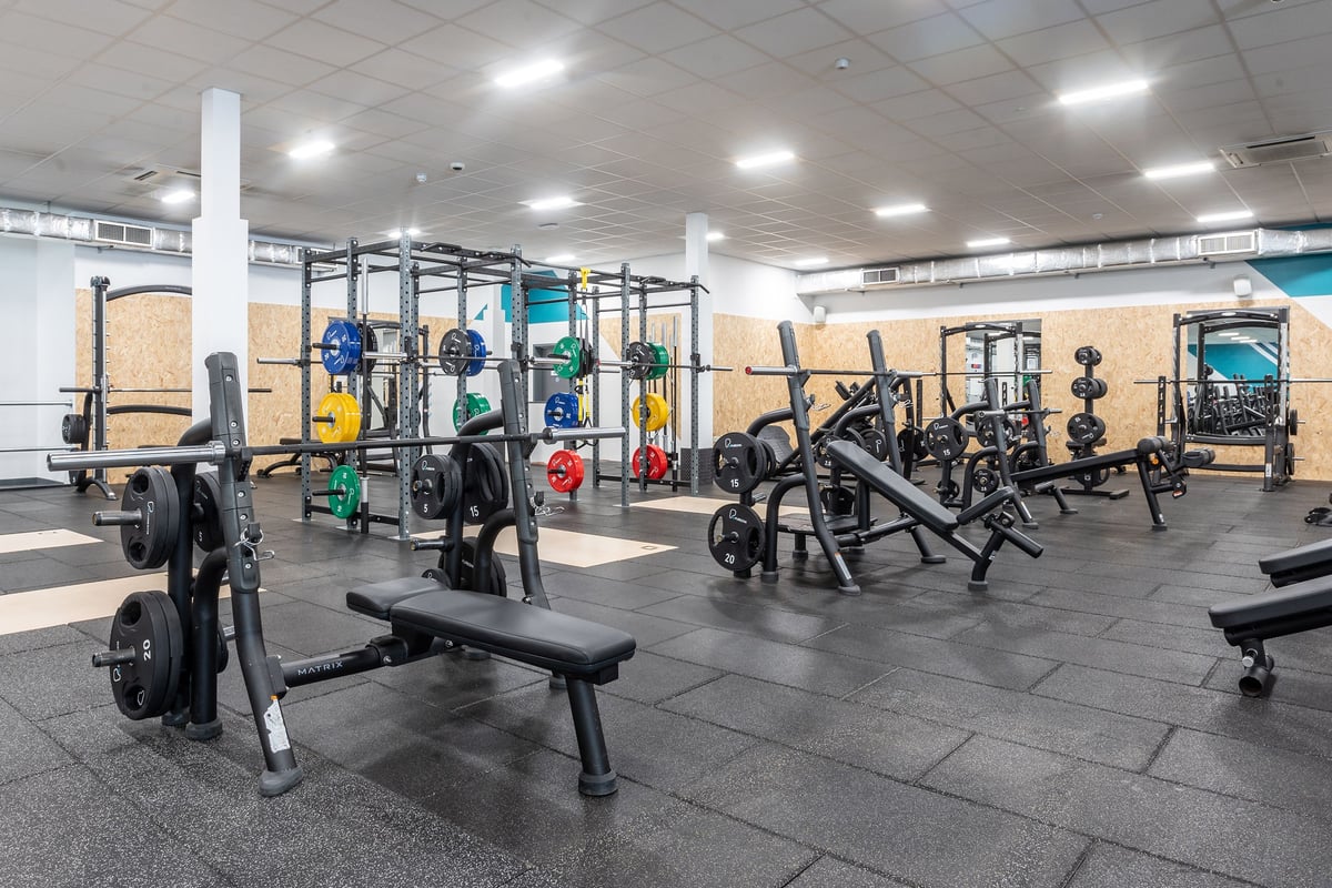 PureGym Coventry Warwickshire Shopping Park: Gym with weight training equipment, benches, racks, and rubberized flooring.