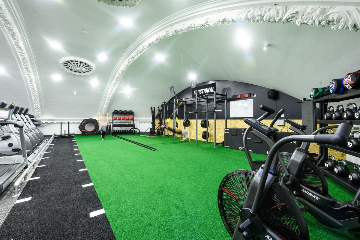 PureGym London Wandsworth: Gym interior with green turf area, free weights, resistance machines, and arched ornate ceiling.