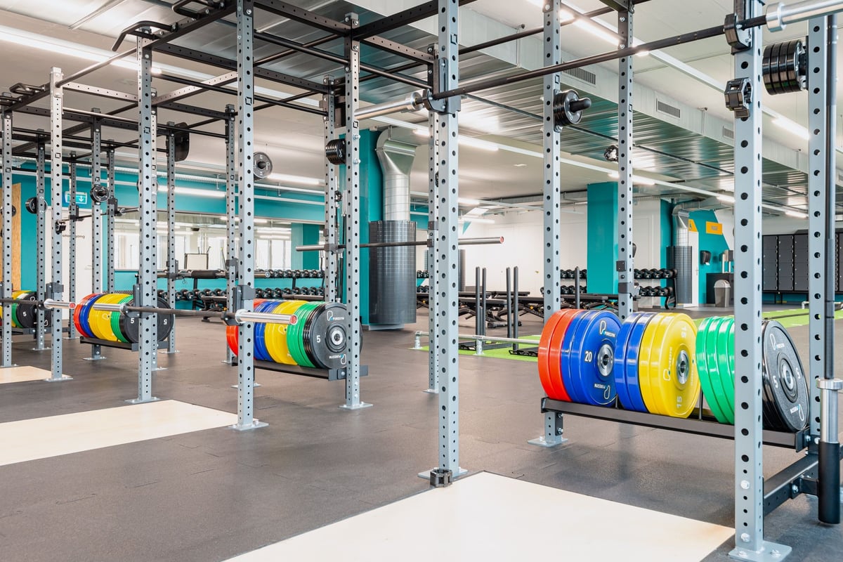 PureGym Altstetten: Krafttrainingsbereich mit Hantelscheibenablagen in verschiedenen Farben.