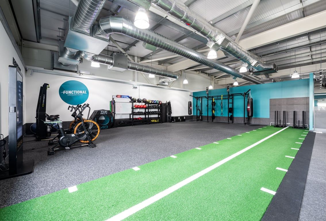 PureGym Portsmouth North Harbour: Gym studio with resistance machines, green turf area, free weights, and workout rigs.