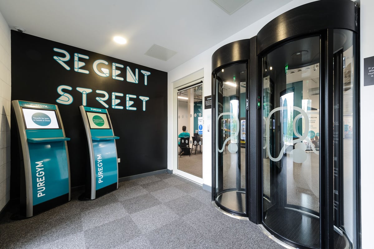 PureGym Leeds Regent Street: Revolving doors, self-service kiosks, and signage for Regent Street.