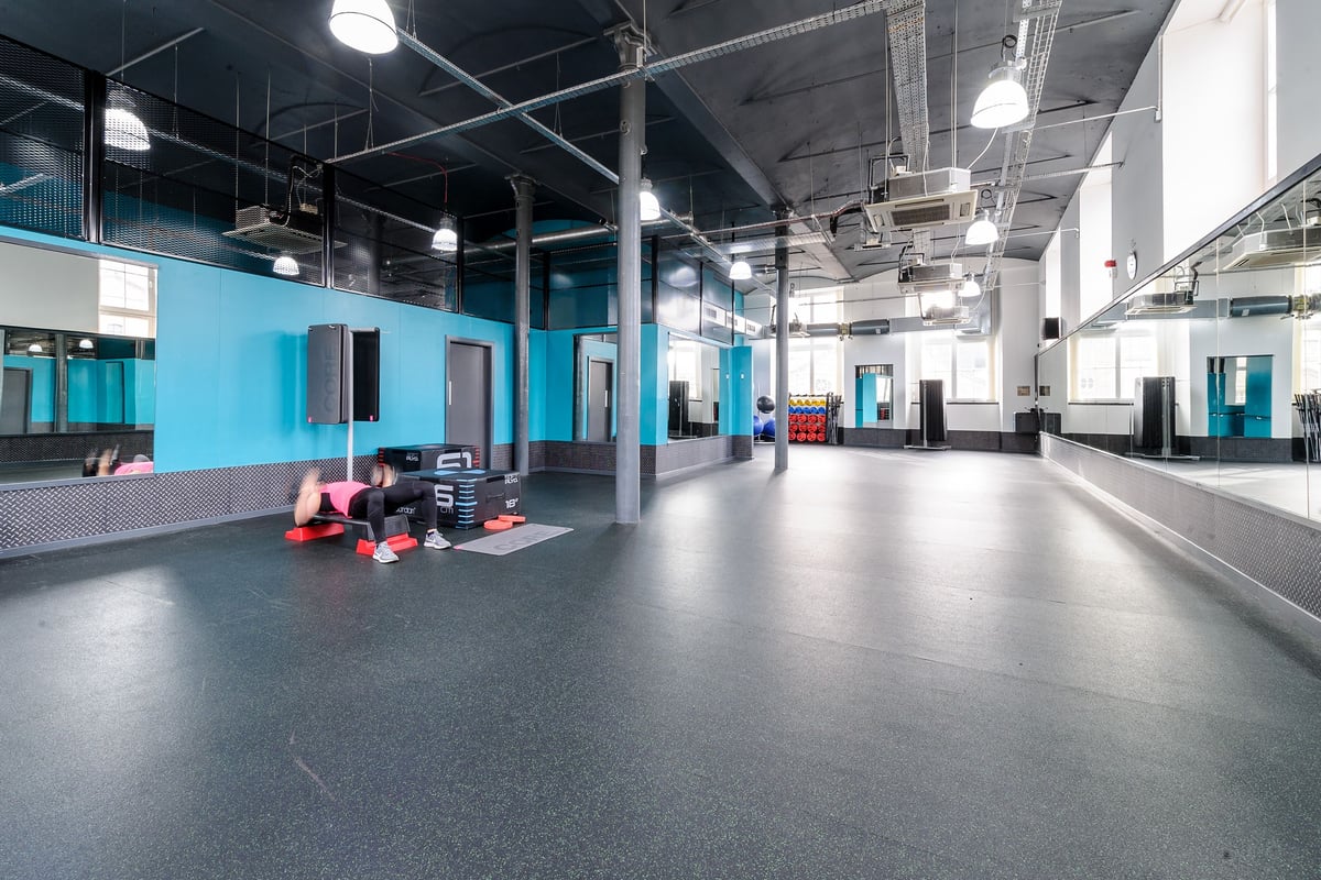PureGym Dundee: Gym floor with resistance bands, medicine balls, and rubberized flooring in blue and white.
