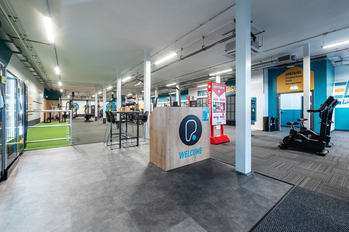 PureGym Letchworth: Welcome desk, turf area, cardio machines, mirrors along walls, rubberized flooring.