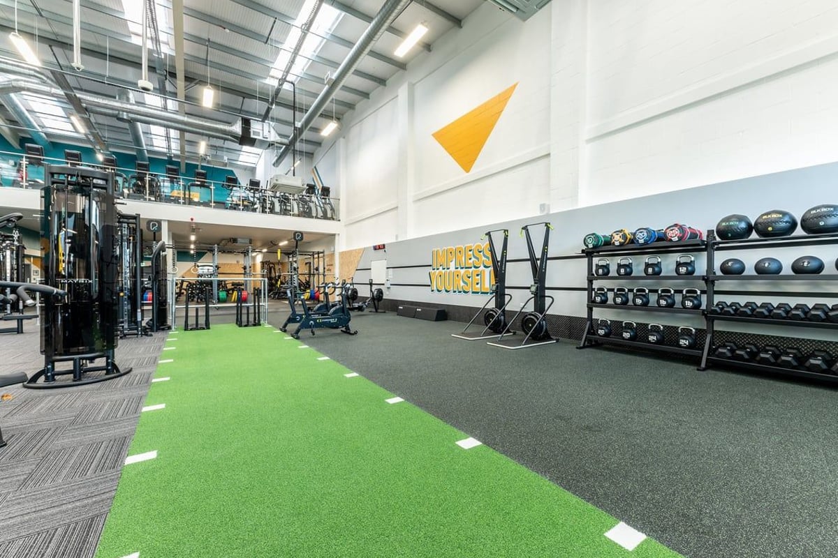 PureGym Consett: Weight racks, resistance machines, free weights, green turf area, and rubberised flooring.