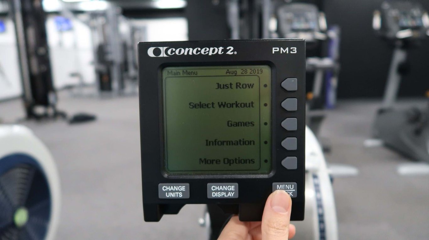 Concept2 PM3 rowing machine monitor showing workout menu options in a gym setting