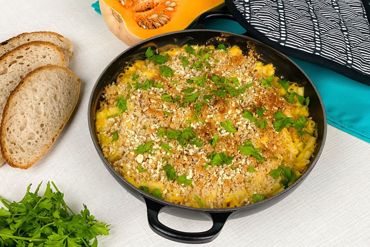 Baked butternut squash macaroni cheese with breadcrumb topping in black skillet