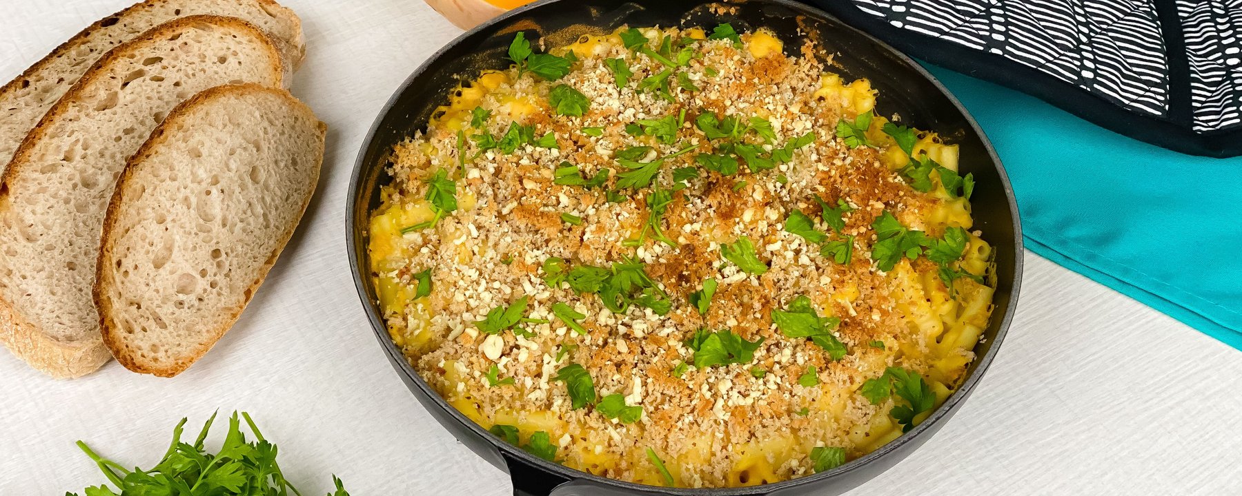 Baked butternut squash macaroni cheese with breadcrumb topping in black skillet
