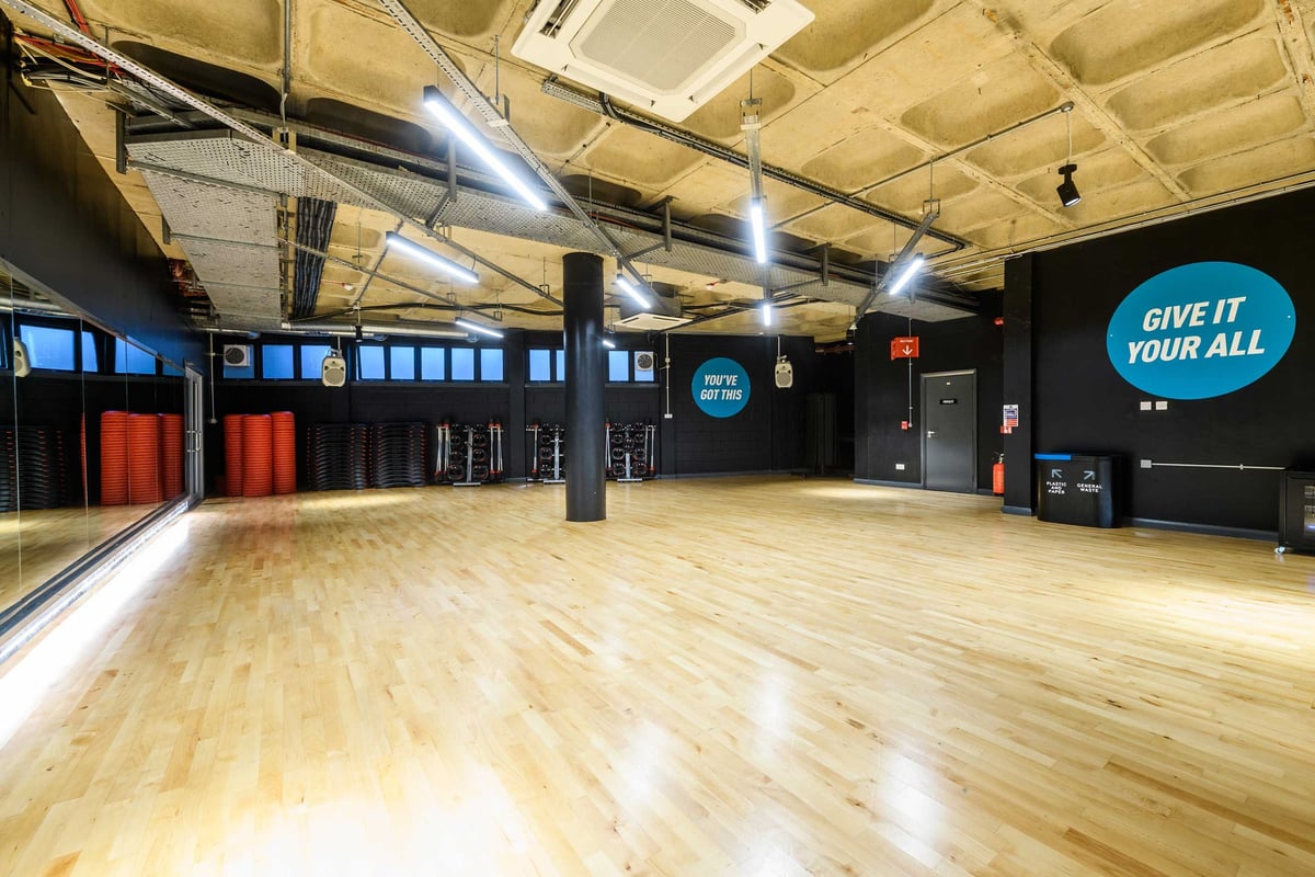 PureGym London Farringdon: Gym studio with wooden flooring, and motivational wall signage.