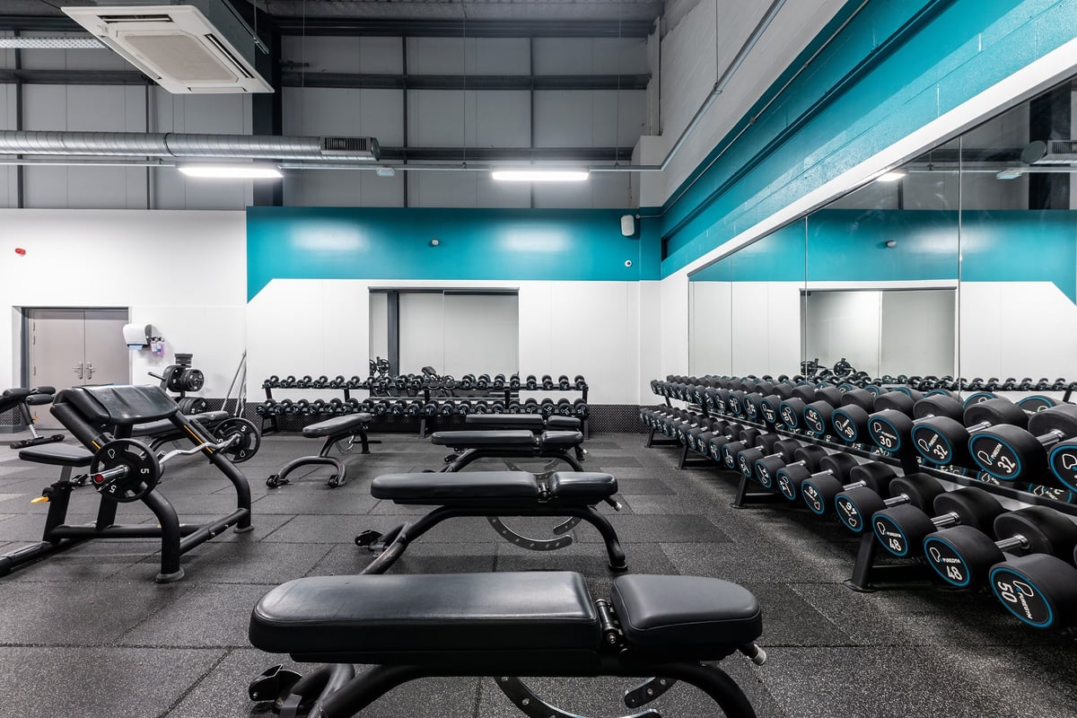 PureGym Chatham: Rows of weight benches, dumbbell racks, and cardio equipment in a brightly-lit gym.
