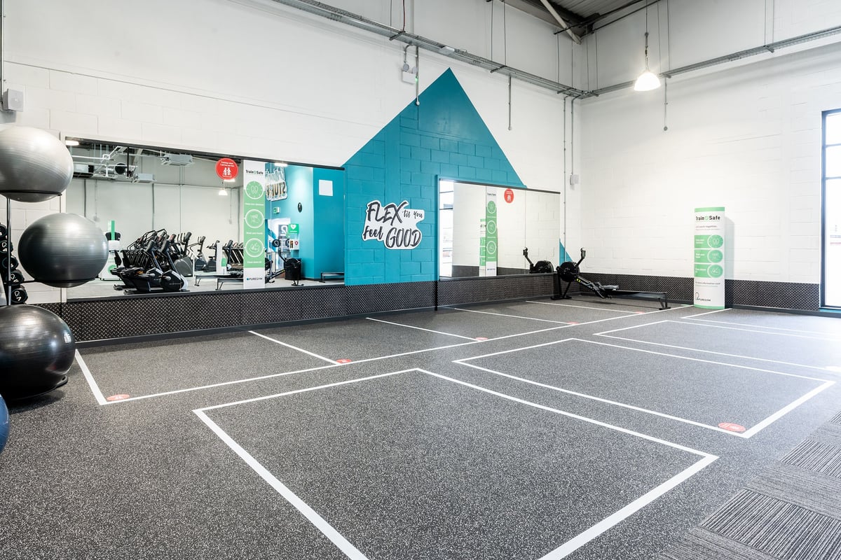 PureGym Stockport North: Exercise studio with rubberised flooring, medicine balls, and a large teal pyramid structure.