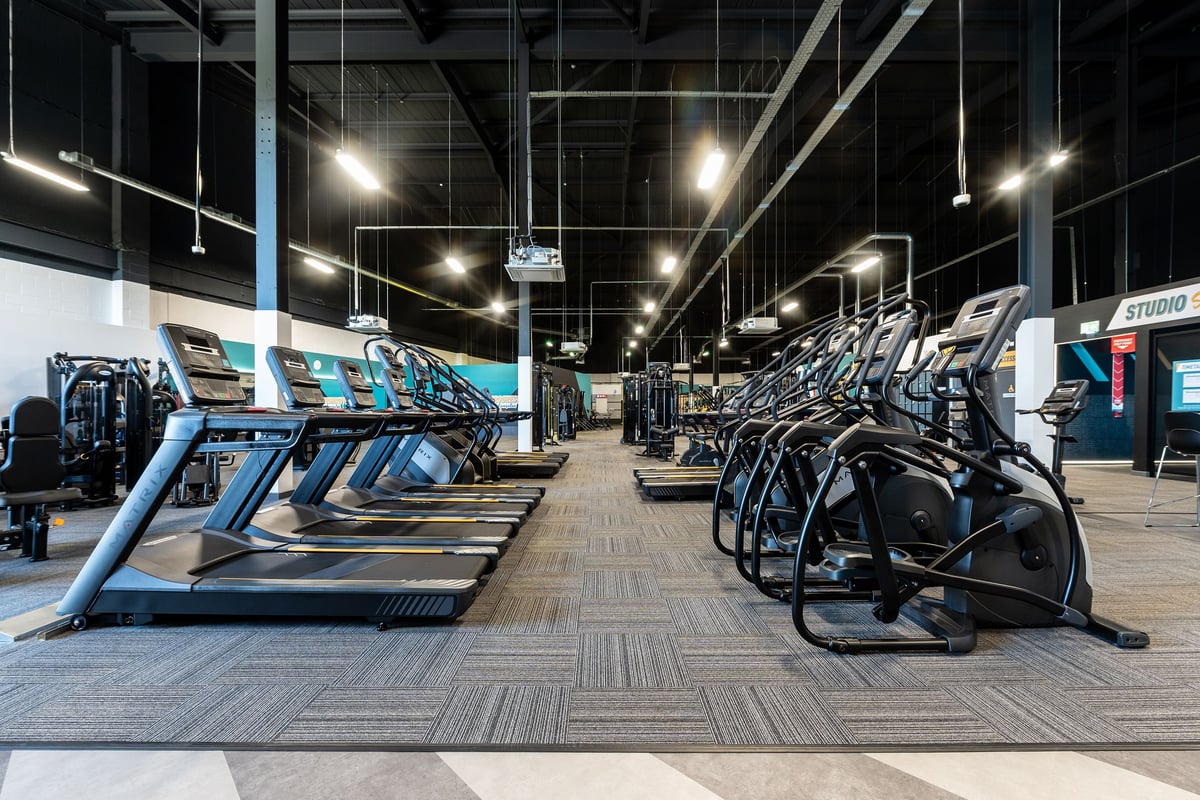PureGym Stockton-on-tees Teesside Park: Rows of treadmills and exercise bikes in a brightly lit gymnasium studio interior.